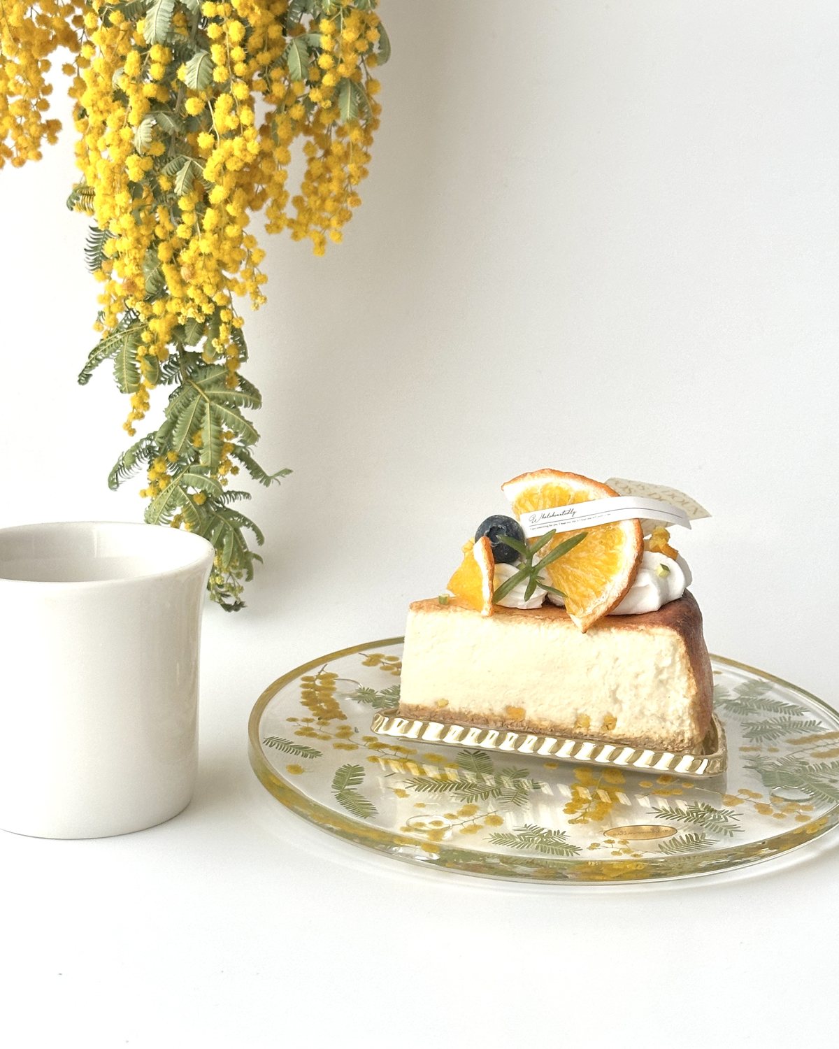 ミモザのお皿にのせたチーズケーキ